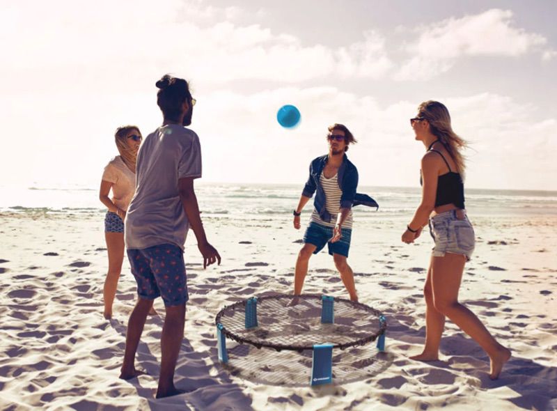 Freunde spielen mit einem Ball am Strand